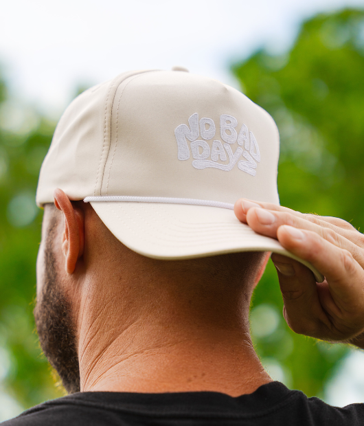 Man wearing white "No bad dayz" hat with white rope brim backwards