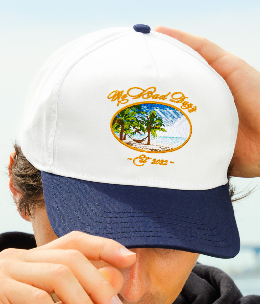 Man wearing no bad days hat with hammock / beach design